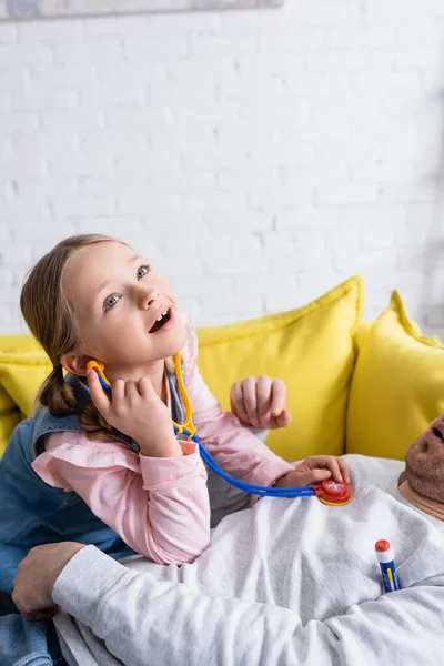 Menina Jogando Médico Examinando Pai Com Estetoscópio Brinquedo — Fotografia de Stock