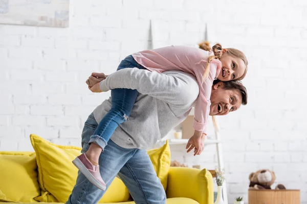 Freudiger Mann Huckepack Aufgeregte Tochter Hause — Stockfoto