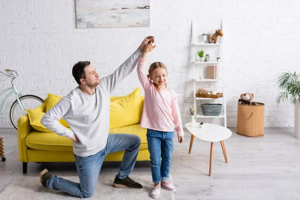 男人跪着和女儿在家里跳舞 — 图库照片
