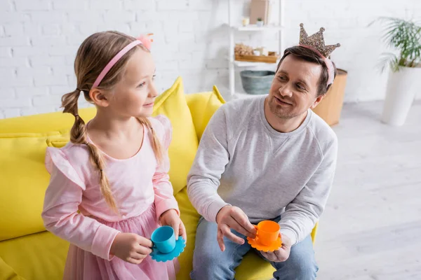Sorrindo Pai Filha Segurando Copos Brinquedo Enquanto Brincava Casa — Fotografia de Stock