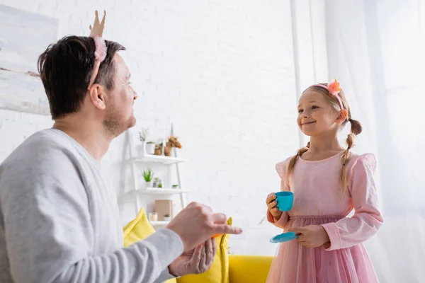 Vrolijk Meisje Speelgoed Kroon Kijken Naar Vader Wazig Voorgrond — Stockfoto