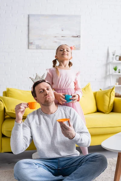 Alegre Filha Pai Olhando Para Câmera Enquanto Segurando Copos Brinquedo — Fotografia de Stock