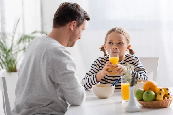Chica Bebiendo Jugo Naranja Cerca Padre Frutas Primer Plano Borrosa — Foto de Stock
