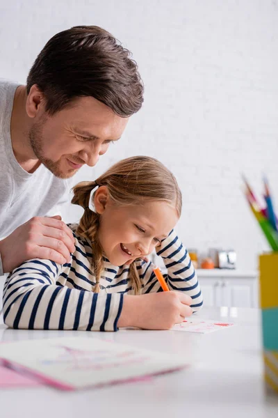 快乐的父亲用毛笔在模糊的前景上触摸着女儿的肩膀 — 图库照片