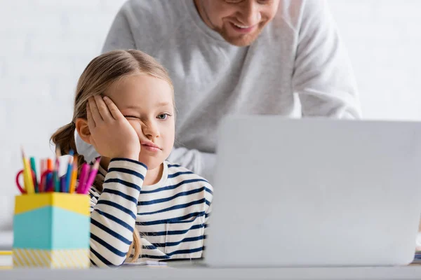 Ojciec Uśmiechający Się Znudzonej Córki Podczas Lekcji Online Domu Zamazany — Zdjęcie stockowe