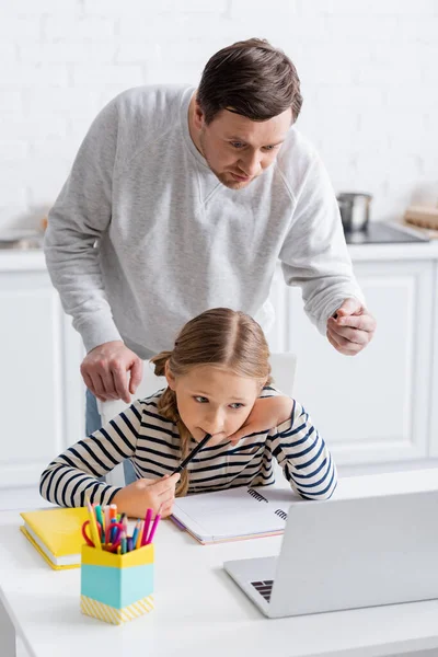 Man Pointing Finger Concentrated Daughter Doing Homework Laptop — Stock Photo, Image