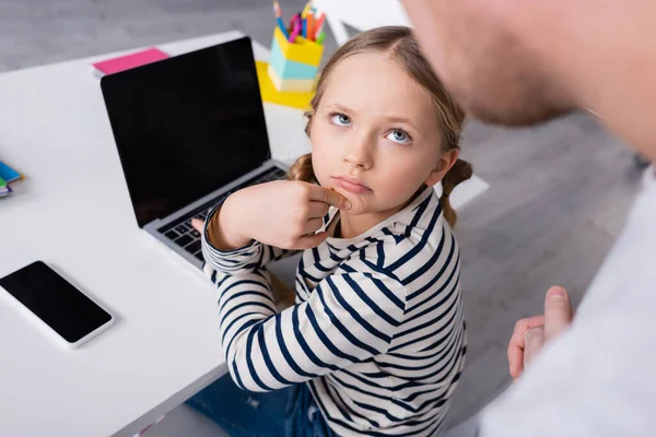 Školačka Při Pohledu Otce Rozmazané Popředí Zatímco Sedí Blízkosti Notebooku — Stock fotografie