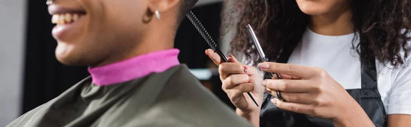 Vista Recortada Peluquería Afroamericana Sosteniendo Tijeras Peine Cerca Cliente Sonriente —  Fotos de Stock