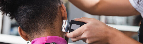 African american hairstylist trimming neck of client, banner 