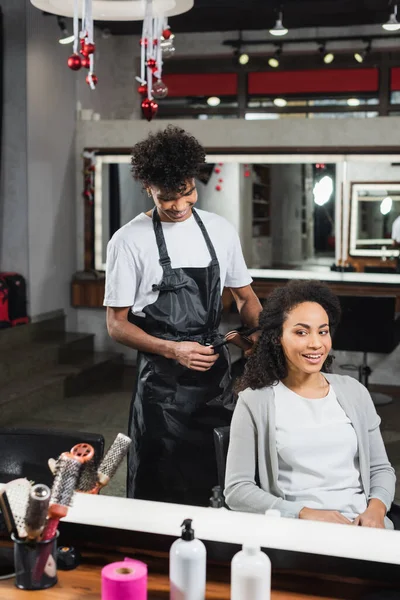 Femme Souriante Assise Près Coiffeur Afro Américain Avec Fer Repasser — Photo