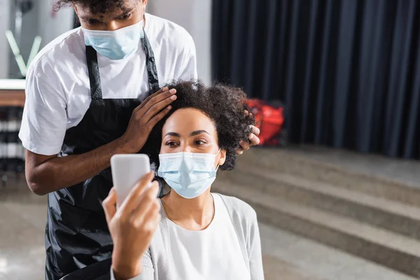 Cliente Afroamericano Máscara Médica Usando Teléfono Inteligente Primer Plano Borroso —  Fotos de Stock