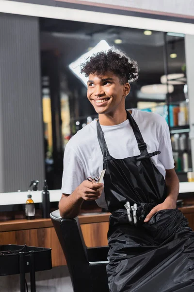 Cabeleireiro Americano Africano Positivo Segurando Tesoura Pente Perto Cadeira — Fotografia de Stock