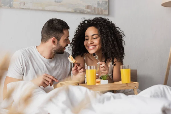 Cheerful Interracial Couple Eating Breakfast Bed — Stock Photo, Image