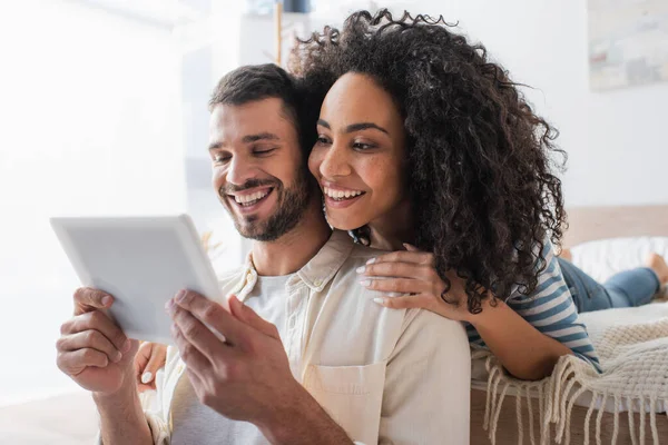 Casal Multiétnico Positivo Olhando Para Tablet Digital — Fotografia de Stock