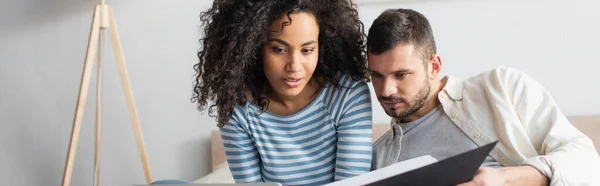 Pareja Interracial Mirando Carpeta Pancarta —  Fotos de Stock