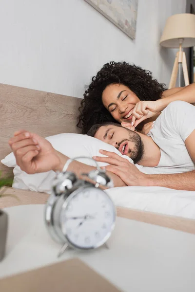 African American Woman Smiling While Touching Ear Bearded Man Sleeping — Stock Photo, Image