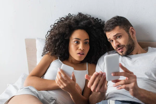 Chocado Interracial Casal Olhando Para Smartphone — Fotografia de Stock