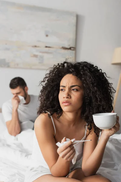 Sick African American Woman Holding Digital Thermometer Cup Boyfriend Blurred — Stockfoto