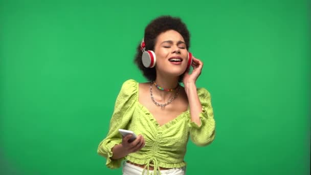 African American Woman Smartphone Headphones Isolated Green — Stock Video