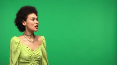 Megafonlu Afrikalı Amerikalı kadın yeşilde izole bir şekilde bağırıyor. 