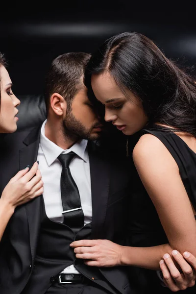 Sexy Frauen Verführen Geschäftsmann Anzug Auf Schwarzem Hintergrund — Stockfoto