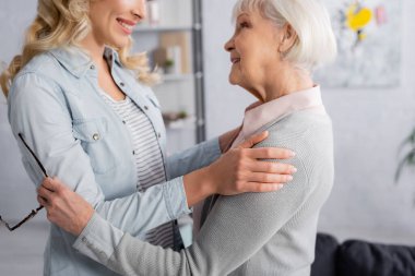 Gözlüklü mutlu yaşlı kadın, sarılıyor kızına 