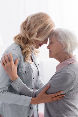 Üst düzey ebeveyn kucaklayan kızının yan görünüşü