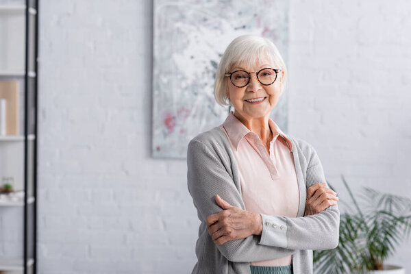 Smiling elderly woman in eyeglasses looking at camera 