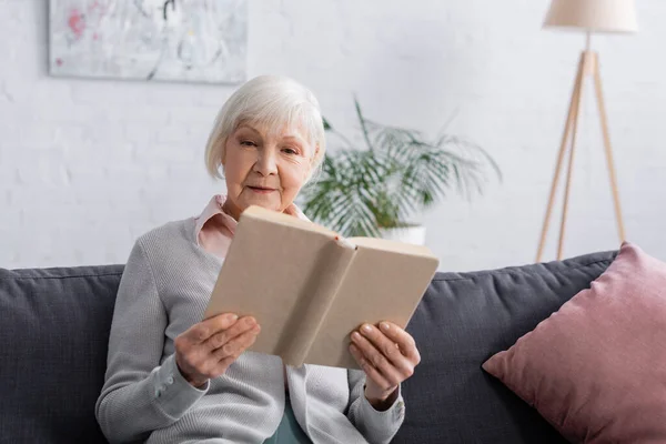 Blurred Book Hands Senior Woman Couch — Stock Photo, Image