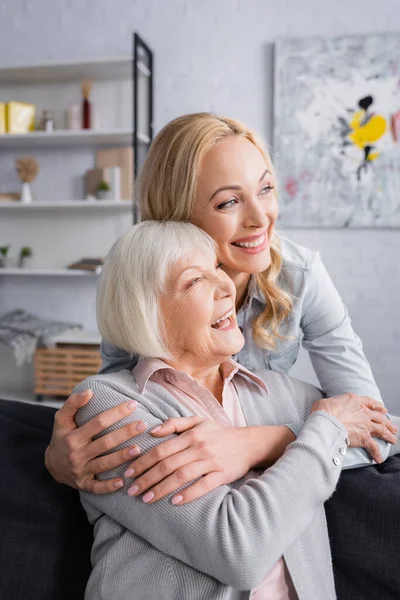 Cheerful Woman Hugging Elderly Mother Living Room — Stock Photo, Image