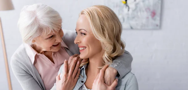 Glada Äldre Kvinna Tittar Dotter Medan Kramas Banner — Stockfoto