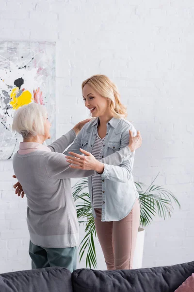 Vrolijke Vrouw Zoek Naar Ouder Buurt Van Bank Woonkamer — Stockfoto