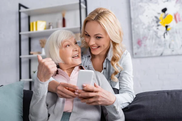 Cheerful Senior Woman Holding Smartphone Showing Gesture Daughter — Stock Photo, Image