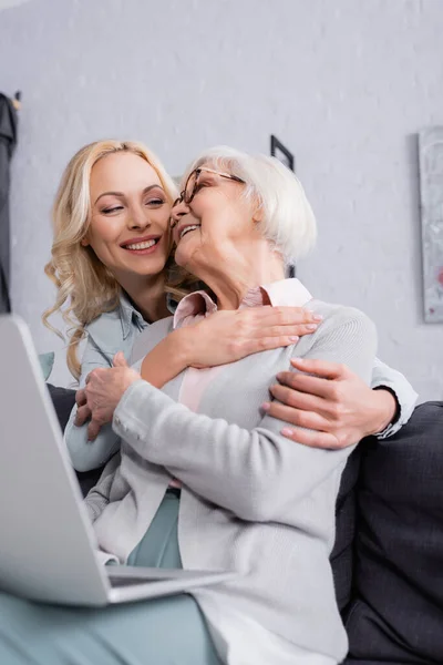 Smiling Women Embracing Laptop Blurred Foreground — Stock Photo, Image