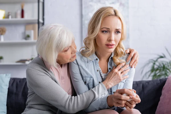 Äldre Förälder Omfamnar Upprörd Dotter Med Servett Soffan — Stockfoto