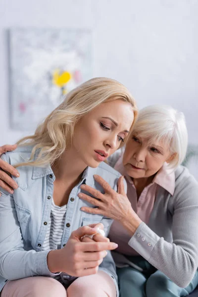 Missnöjd Kvinna Sitter Nära Gråhårig Mor Vardagsrummet — Stockfoto