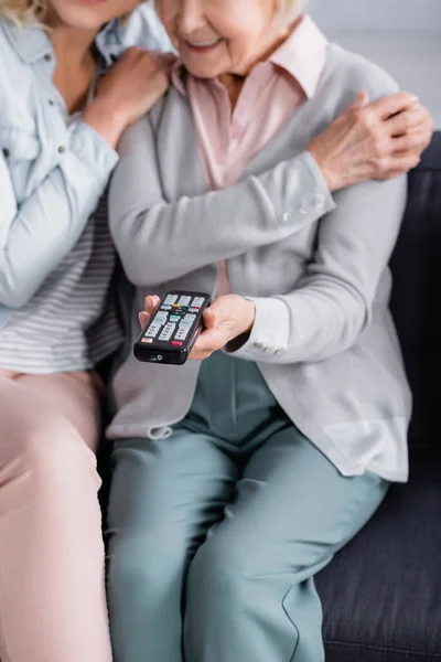 Ausgeschnittene Ansicht Der Fernbedienung Der Hand Einer Reifen Frau Der — Stockfoto