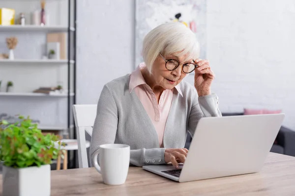 Seniorin Mit Brille Benutzt Laptop Der Nähe Der Tasse — Stockfoto