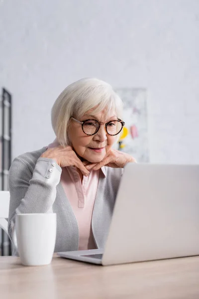 Senior Woman Eyeglasses Looking Laptop Cup — Stock Photo, Image