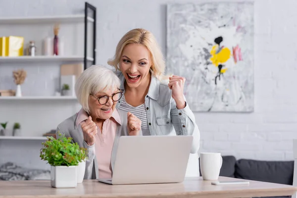 Alegre Madre Hija Mostrando Gesto Cerca Del Ordenador Portátil Tazas — Foto de Stock