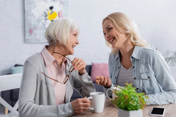 Neşeli Kadın Çay Akıllı Telefonun Yanında Yaşlı Anneyle Konuşuyor — Stok fotoğraf