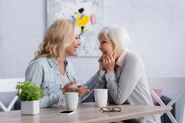 Senior Woman Smiling Daughter Cups Smartphone — Stock Photo, Image