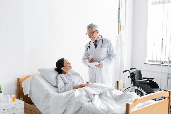 Medico Sorridente Che Tiene Tablet Digitale Mentre Parla Con Donna — Foto Stock