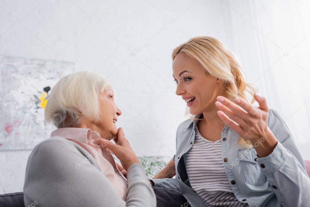 Smiling mother and daughter talking at home 