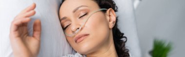 overhead view of ill african american woman with nasal cannula sleeping in hospital bed, banner clipart