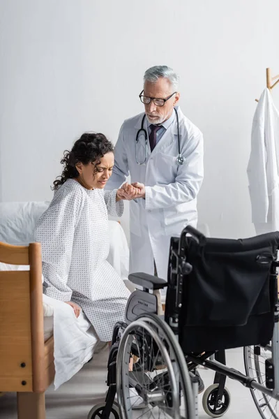 Mature Doctor Helping African American Woman Getting Hospital Bed Wheelchair — Stock Photo, Image