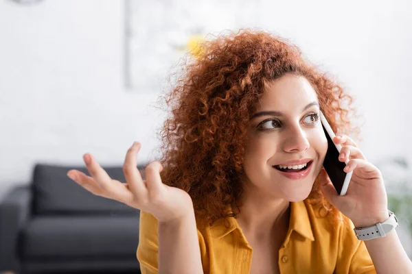 Freelancer Encaracolado Sorrindo Gesticulando Enquanto Fala Celular — Fotografia de Stock