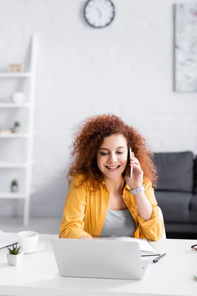 Freelancer Sorrindo Chamando Smartphone Perto Laptop Casa — Fotografia de Stock