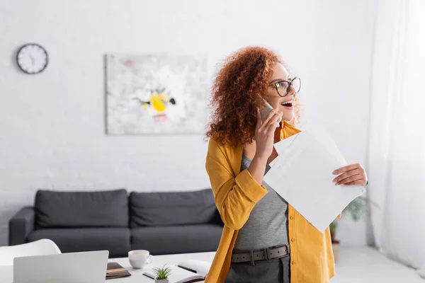 Excited Teleworker Holding Documents While Talking Cellphone Home — Stock Photo, Image