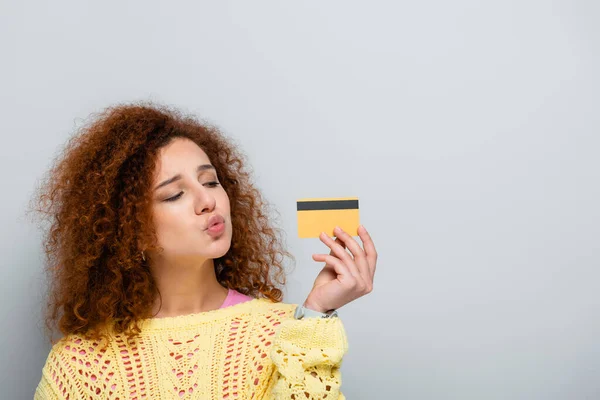 Curly Woman Blowing Air Kiss While Holding Credit Card Isolated — Stock Photo, Image